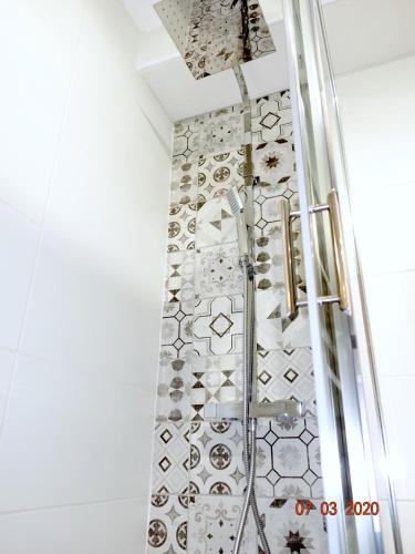 une douche dans une salle de bain avec un mur carrelé dans l'établissement Grand studio, Ramblas de Toulouse, Jean Jaurès, à Toulouse