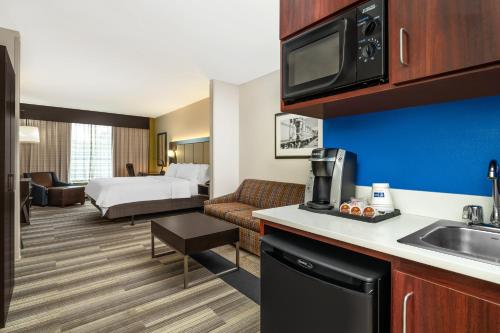 a hotel room with a kitchen and a bedroom at Holiday Inn Express & Suites Florence by IHG in Florence