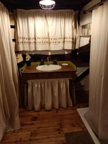 a bathroom with a sink and a shower with curtains at casa rural decerca in Arcones