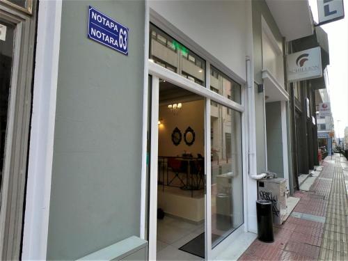 a store front with a sign on the side of a building at Achillion Hotel Piraeus in Piraeus