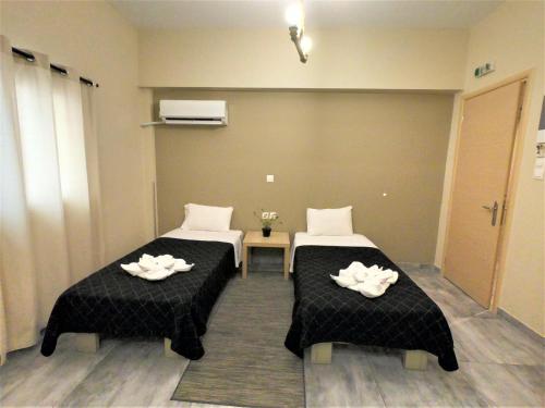 a room with two beds with towels on them at Achillion Hotel Piraeus in Piraeus