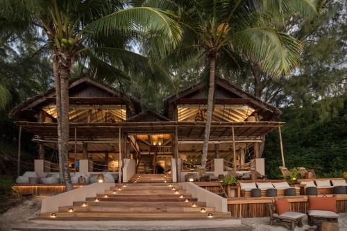 a resort with palm trees and a building with stairs at Constance Tsarabanjina - All Inclusive in Nosy Mitsio