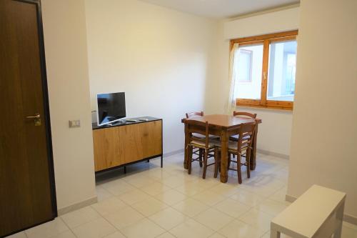 a room with a table and a tv and a table and chairs at Flamingo view in Quartu SantʼElena