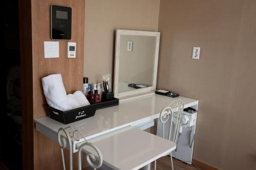 een badkamer met een wastafel met spiegel en stoelen bij YD Residence in Seoul
