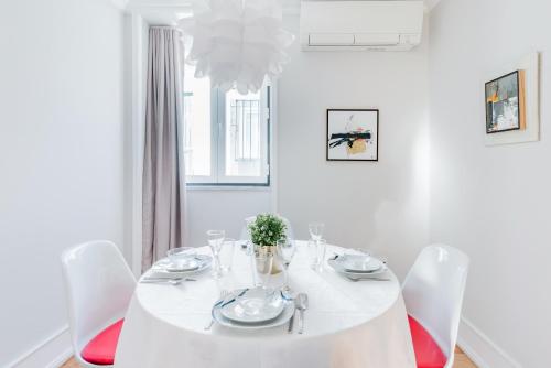 Un comedor blanco con una mesa y sillas blancas. en Lisbon Center V, en Lisboa