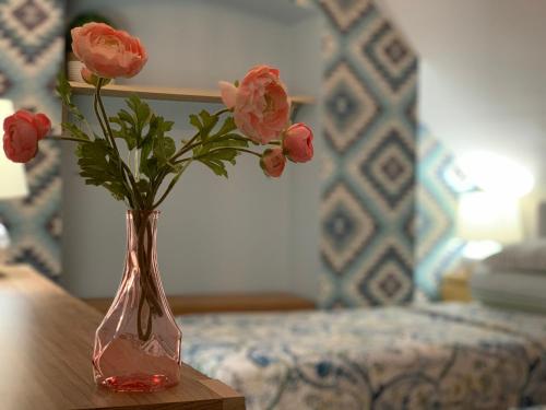 a vase with pink flowers sitting on a table at Apartamenty Dobranocka in Krotoszyn