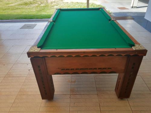 a green pool table sitting on a tile floor at Vista Oceanica Pousada in Marataizes
