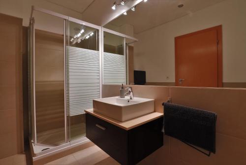 a bathroom with a sink and a shower at Castle in Blue Apartments-Sea View in Sines