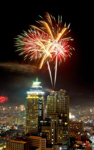 a fireworks display over a city at night at Crown Regency Hotel & Towers in Cebu City