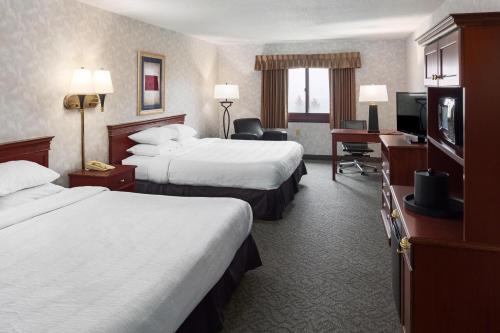 a hotel room with two beds and a flat screen tv at Grand Hotel in Minot