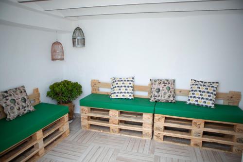 um quarto com bancos de madeira com almofadas em Casa rural RIUIVIU em Biar