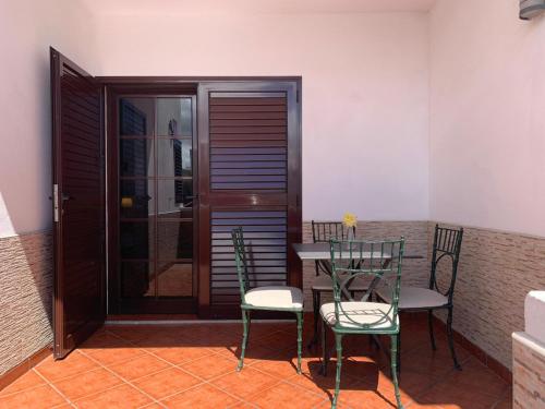 a patio with two chairs and a table and a door at CHEGAMOS in Punta de Mujeres