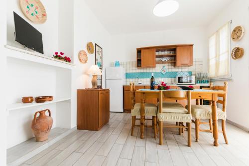 a kitchen and dining room with a table and chairs at Residence Fior di Sulcis in Calasetta