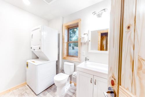 a white bathroom with a toilet and a sink at Little Doe Cabin in Woodland Park