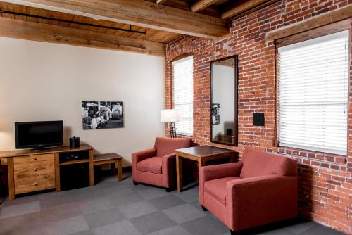 a living room with two chairs and a tv at Cork Factory Hotel in Lancaster