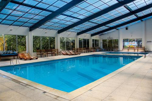 a large swimming pool with a glass ceiling at Monreale Resort Parque Aquático in Poços de Caldas