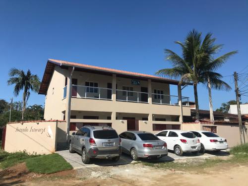 a building with three cars parked in front of it at Recanto Lorenzi - Apartamentos in Ubatuba