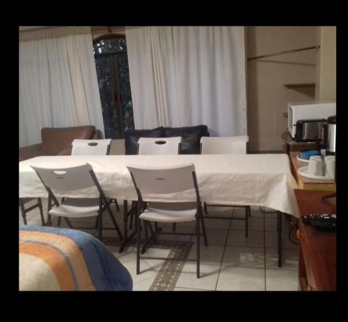 a white table and chairs in a room with a kitchen at CIUDAD DE MEXICO UNAM Guest House Casa de Huespedes in Mexico City
