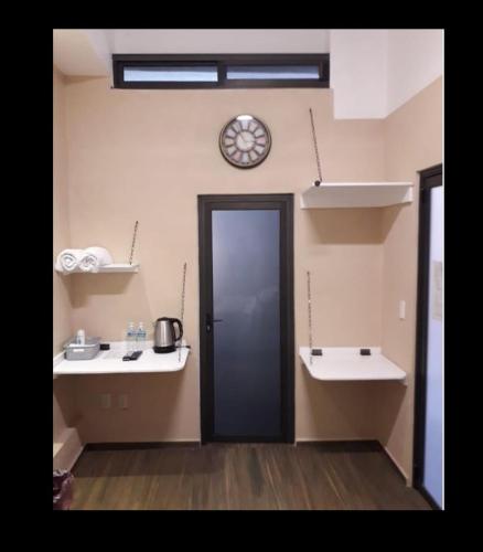 a room with a door and a clock on the wall at CIUDAD DE MEXICO UNAM Guest House Casa de Huespedes in Mexico City