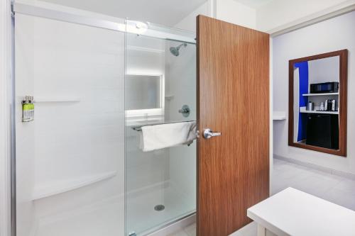 W łazience znajduje się prysznic ze szklanymi drzwiami. w obiekcie Holiday Inn Express & Suites - Tulsa Northeast - Owasso, an IHG Hotel w mieście Owasso
