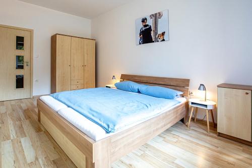 a bedroom with a large bed with blue sheets at Apartmán Lipno 50/18 in Lipno nad Vltavou