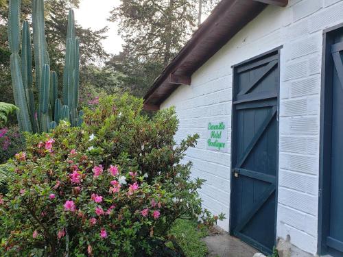 a blue building with a blue door and flowers at Ensenillo Hotel Boutique in Rionegro