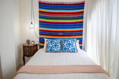 een slaapkamer met een bed met een kleurrijk gordijn bij Private Studio in Shenandoah - 4K in Miami