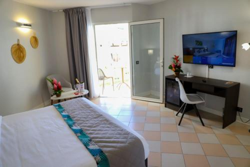 a bedroom with a bed and a desk and a television at Hôtel Saint-Georges in Saint-Claude