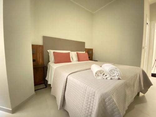a bedroom with two beds with white sheets and pink pillows at Villa Antonino in Giardini Naxos