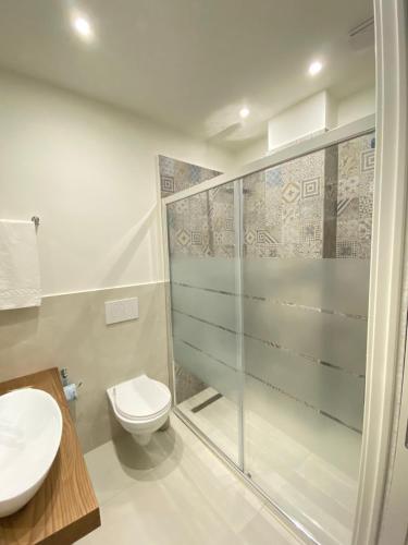 a bathroom with a toilet and a glass shower at Villa Antonino in Giardini Naxos
