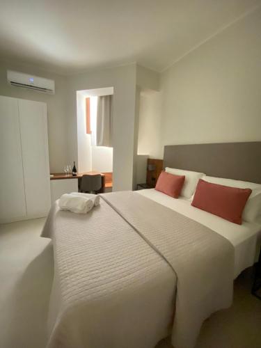 a bedroom with a large white bed with two red pillows at Villa Antonino in Giardini Naxos