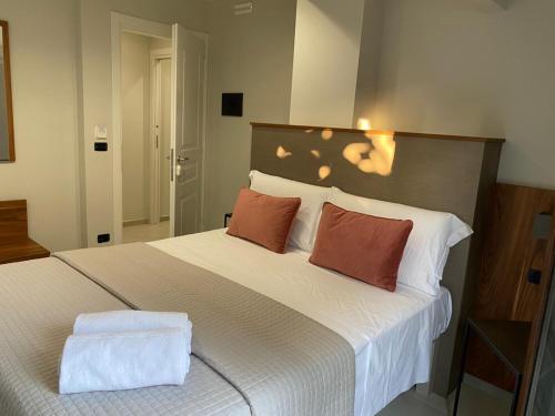 a bedroom with a large white bed with two pillows at Villa Antonino in Giardini Naxos