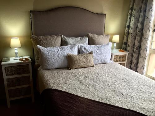 1 dormitorio con 1 cama grande con almohadas en Summer Vintage Home in Gonubie - just a Walk to the Beach!, en East London