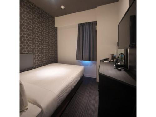 a small room with a bed and a dresser and a bed sidx sidx sidx at Hotel Halrotto Fukuoka Hakata - Vacation STAY 04192v in Fukuoka