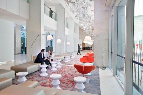 a lobby with white chairs and red accents at Capri by Fraser Changi City, Singapore in Singapore