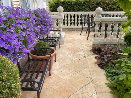 a row of benches with purple flowers on a patio at Wilsmann Apartmentvermietung in Hövelhof