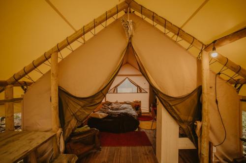 a bedroom with a bed inside of a tent at Torma Puhkemaja ja Glämping in Torma