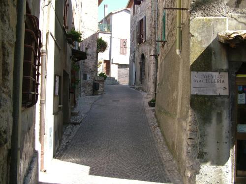 an alley in an old town with a sign on a building at Amazing Lake View in Castel di Tora