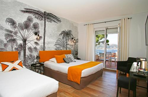 a hotel room with two beds and a desk and a room with a table at Le Saint Erasme, Hotel Eco Friendly in Calvi