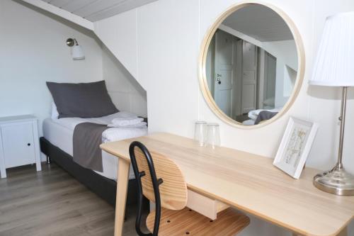 a bedroom with a desk and a bed with a mirror at Miðhraun - Lava resort in Midhraun
