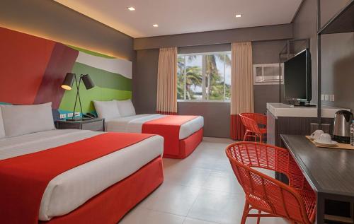 Habitación de hotel con 2 camas y escritorio en Boracay Uptown en Boracay