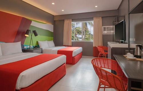 a hotel room with two beds and a desk at Boracay Uptown in Boracay