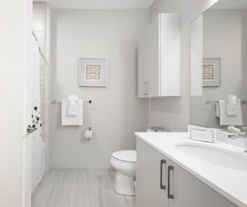 a white bathroom with a toilet and a sink at Global Luxury Suites East Boston in Boston