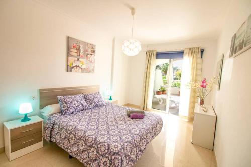 a bedroom with a bed with a purple comforter at Apartamento San Remo Soleado in Palm-Mar