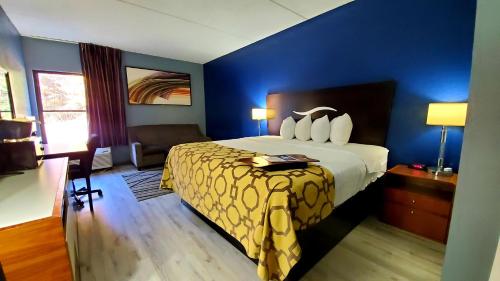 ein Hotelzimmer mit einem Bett und einer blauen Wand in der Unterkunft Baymont by Wyndham London KY in London