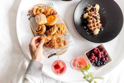 una mesa con una persona sosteniendo un plato de comida en Crowne Plaza Melbourne by IHG, en Melbourne