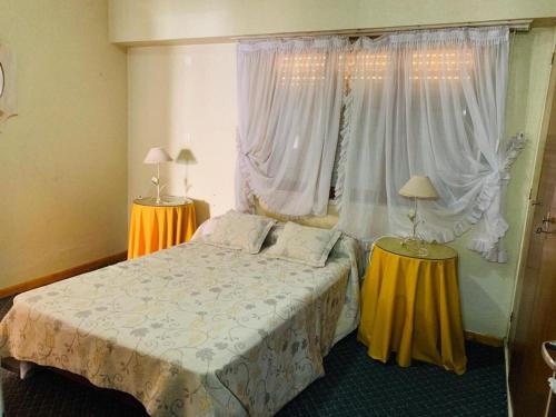 a bedroom with a bed and two tables with lamps at Novator Playa in Mar del Plata