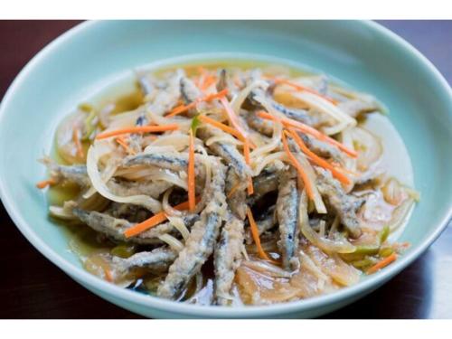 a bowl of soup with noodles and carrots on a table at Hotel Taisei Annex - Vacation STAY 05189v in Kagoshima