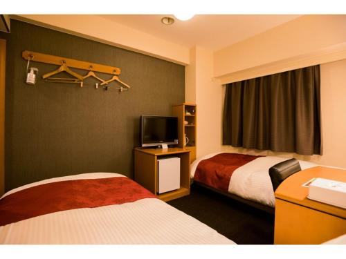 a hotel room with two beds and a television at Hotel Taisei Annex - Vacation STAY 05183v in Kagoshima