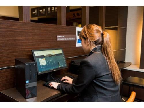 a woman sitting at a desk with a computer at Hotel Taisei Annex - Vacation STAY 05186v in Kagoshima